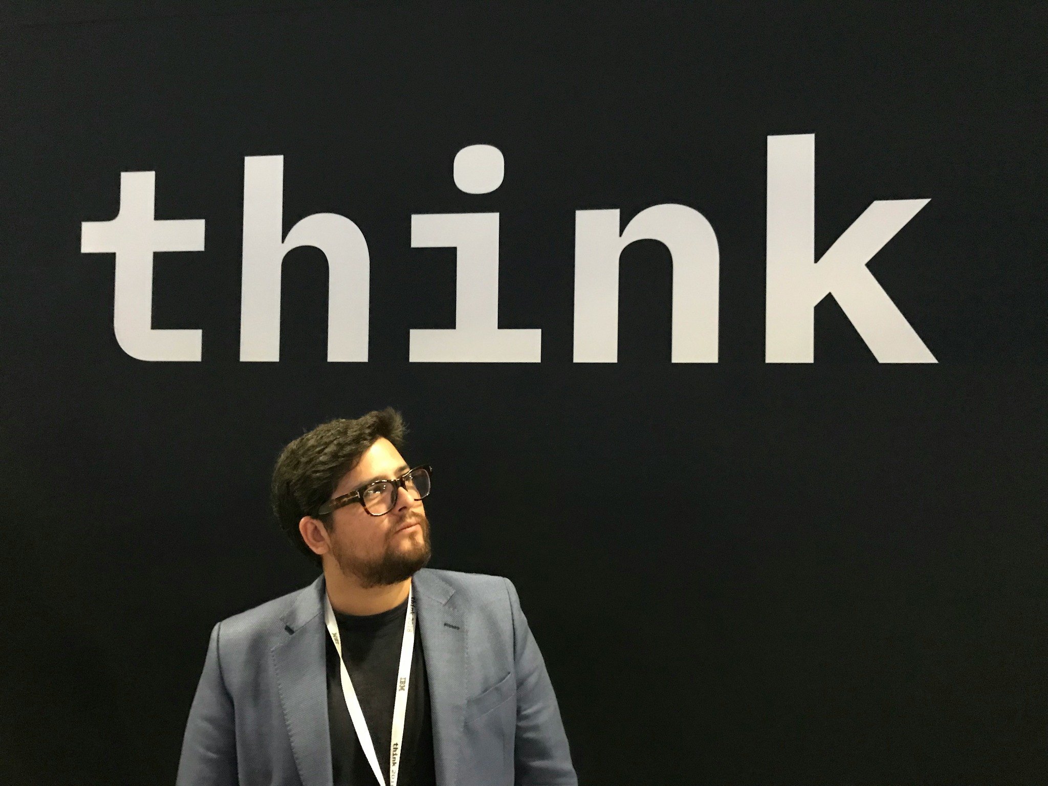 THINKと書かれた壁の前に座る人物