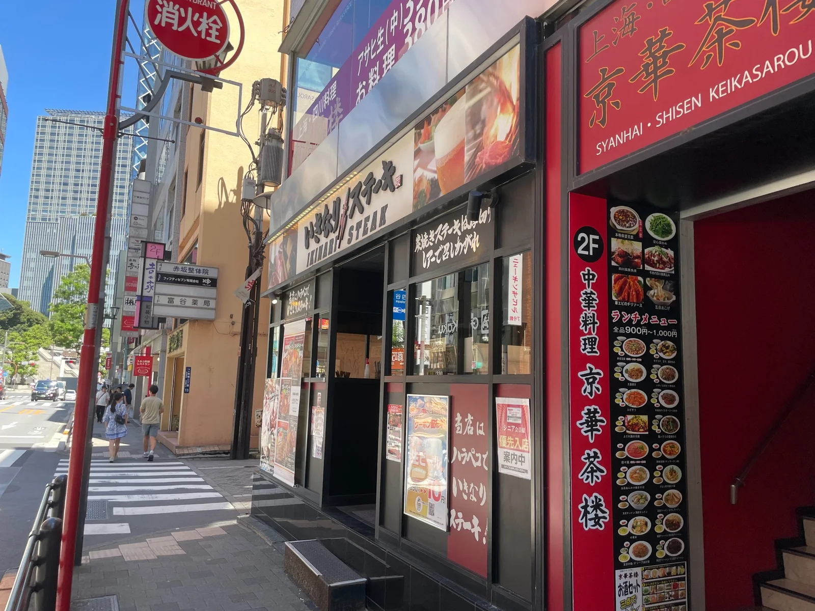 赤い外装の「京華茶楼」と「いきなり！ステーキ」の看板が並ぶ建物の角