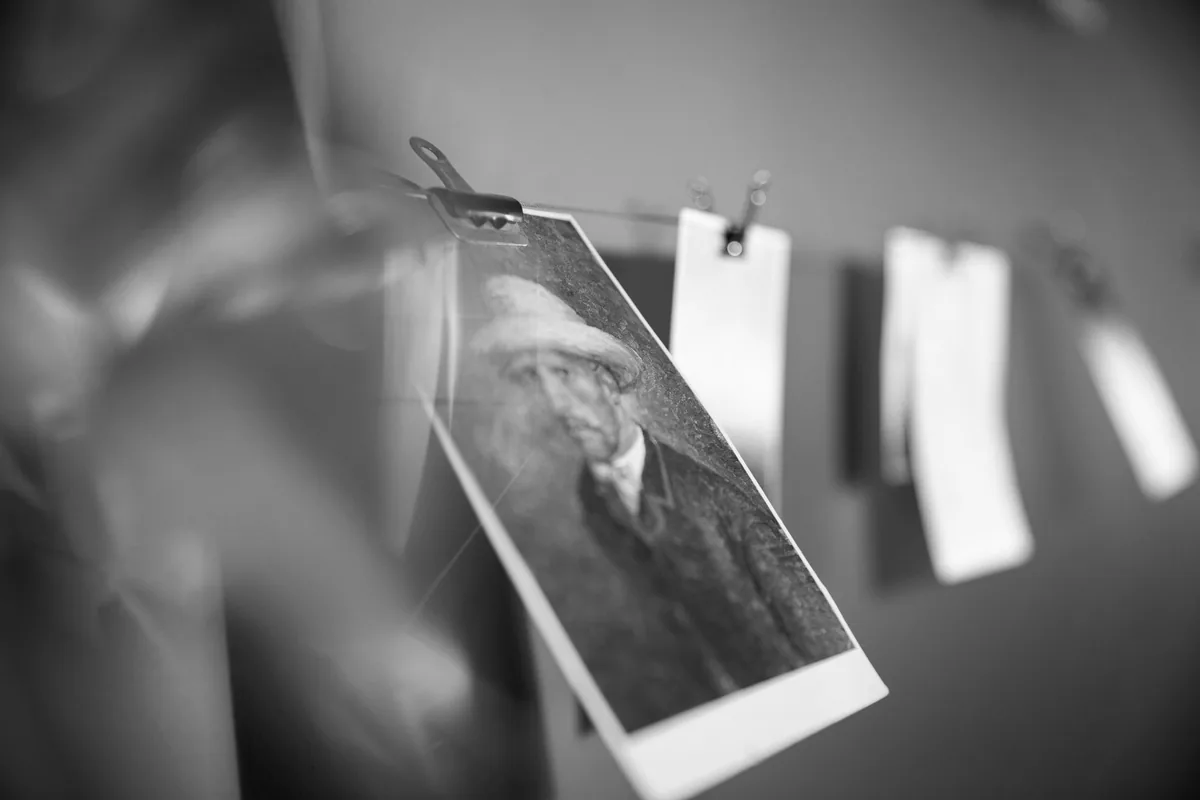 机の上に広げられた複数の写真のモノクロ写真