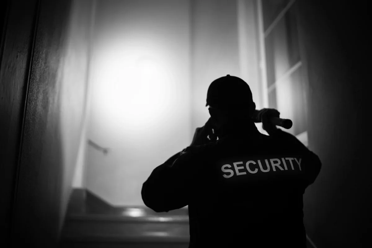 夜間の通りを見回る警備の様子をとらえたモノクロ写真